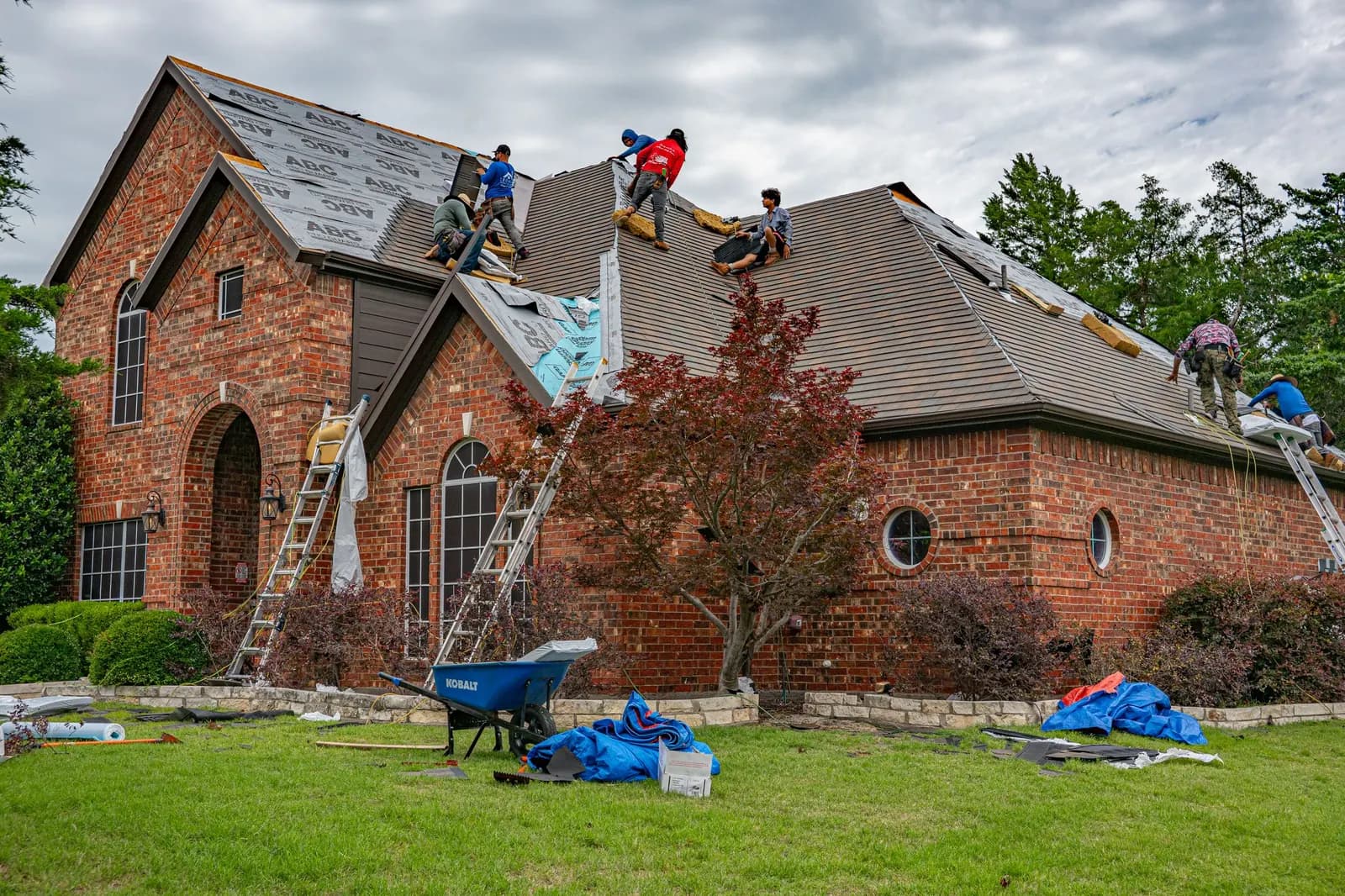 Roofing crew replacing a roof on a brick home