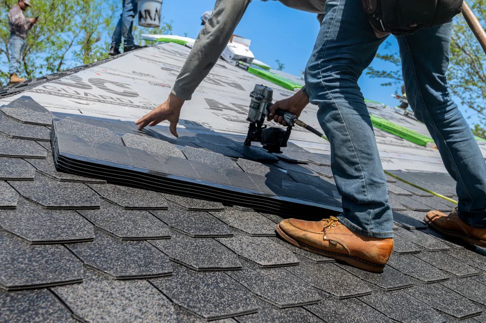 Roofer nailing new shingles